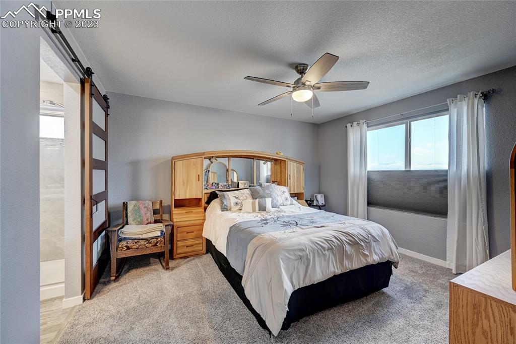 9642 Timberlake Loop Colorado Springs, CO 80927 - Photo 28 of 46 a bedroom with a bed and a chandelier