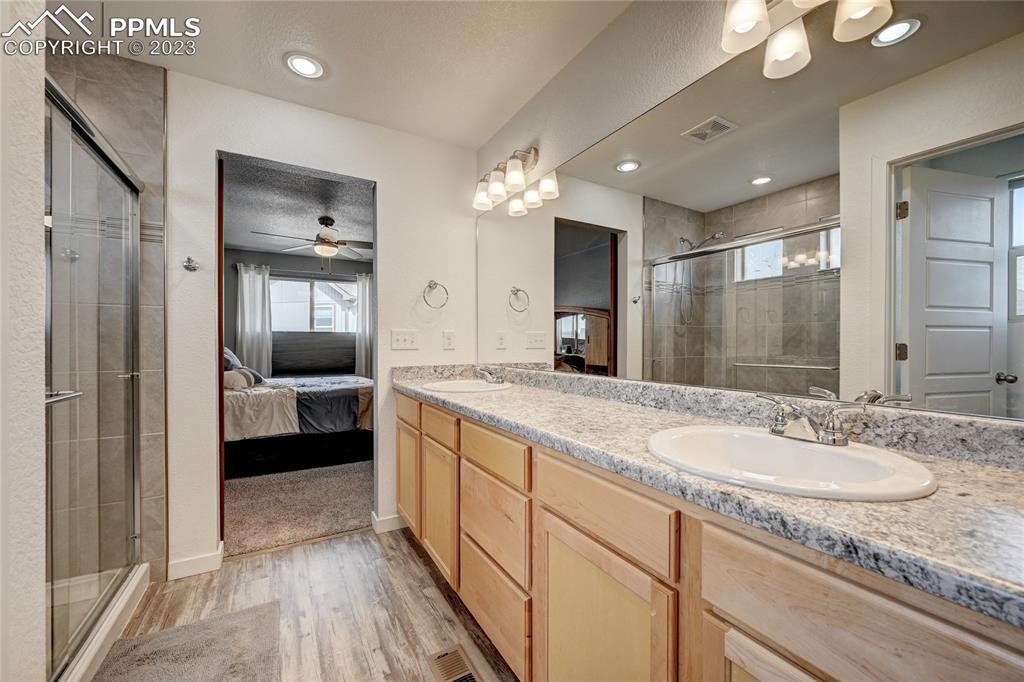 9642 Timberlake Loop Colorado Springs, CO 80927 - Photo 32 of 46 a spacious bathroom with a granite countertop sink mirror and shower