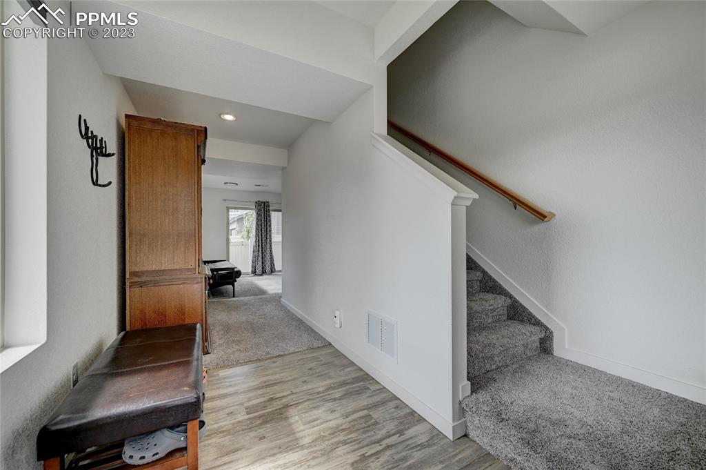 9642 Timberlake Loop Colorado Springs, CO 80927 - Photo 6 of 46 a view of a hallway with wooden floor and staircase