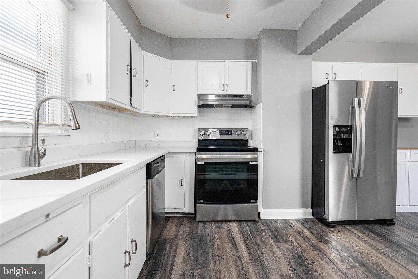 303 Miles Road Essex, MD 21221 - Photo 11 of 37 a kitchen with a refrigerator sink and cabinets
