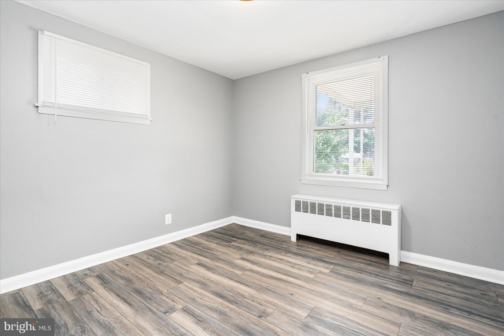 303 Miles Road Essex, MD 21221 - Photo 13 of 37 an empty room with wooden floor and windows