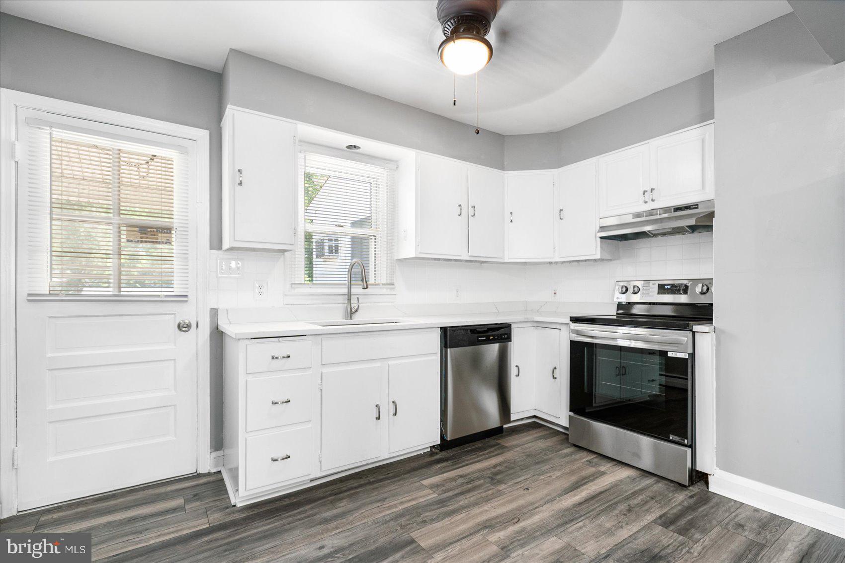 303 Miles Road Essex, MD 21221 - Photo 9 of 37 a kitchen with granite countertop white cabinets stainless steel appliances and a window