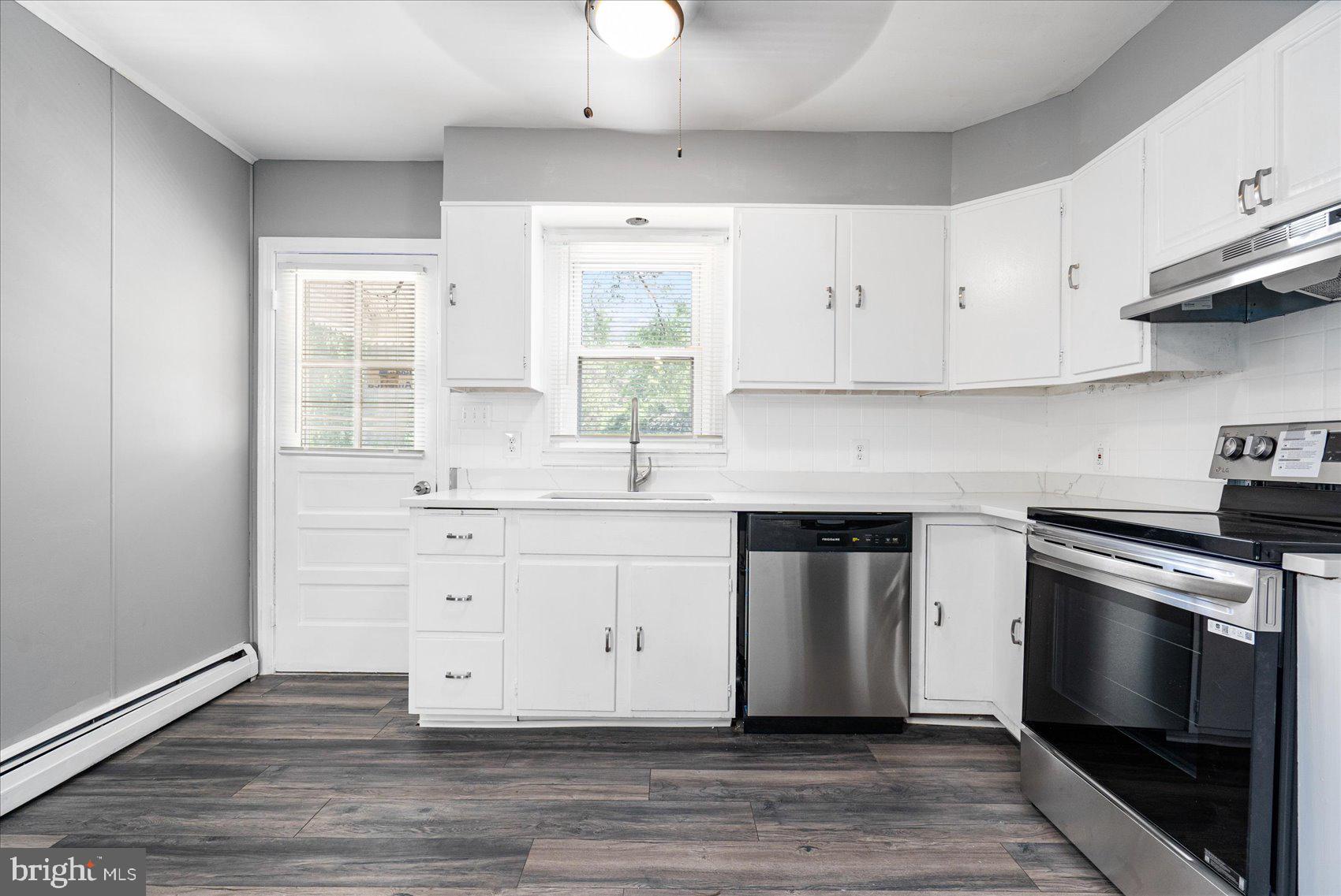 303 Miles Road Essex, MD 21221 - Photo 10 of 37 a kitchen with cabinets wooden floor and a window