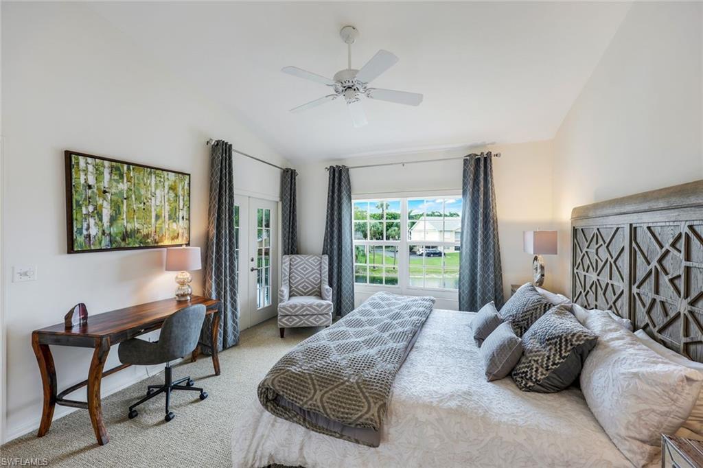 437 Wiggins Lake Court, Unit 201 Naples, FL 34110 - Photo 13 of 24 a bedroom with a bed and a chandelier