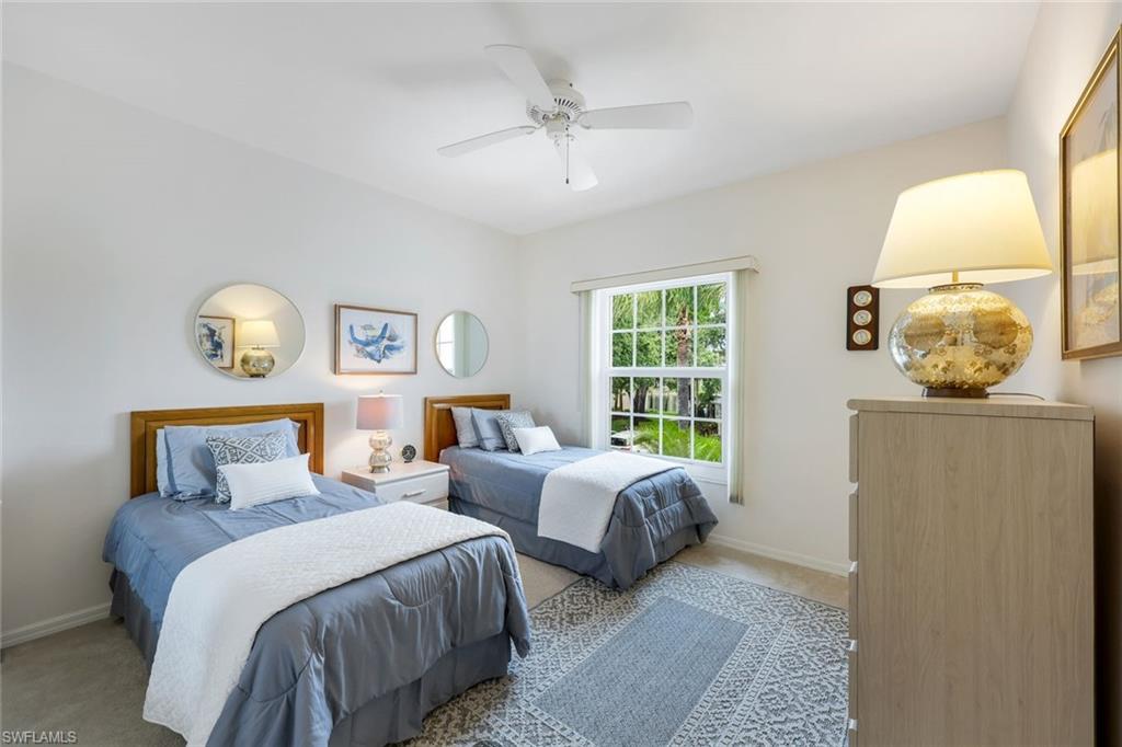437 Wiggins Lake Court, Unit 201 Naples, FL 34110 - Photo 15 of 24 a bedroom with two beds and a chandelier