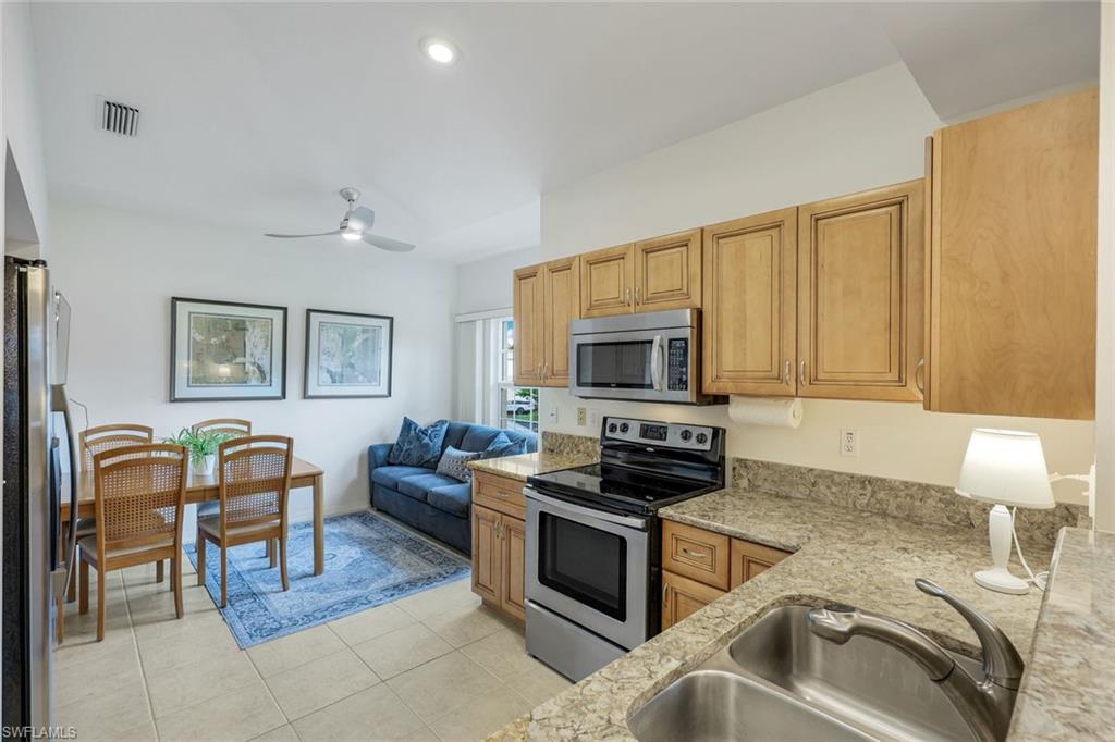 437 Wiggins Lake Court, Unit 201 Naples, FL 34110 - Photo 8 of 24 a kitchen that has a sink and a stove top oven