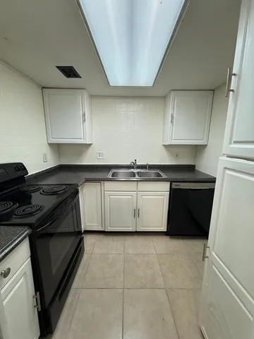 a kitchen with a stove sink and cabinets