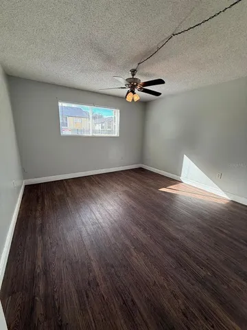 a view of empty room with wooden floor