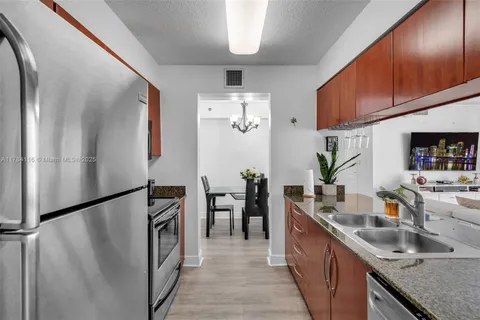a kitchen with stainless steel appliances granite countertop a refrigerator and a sink