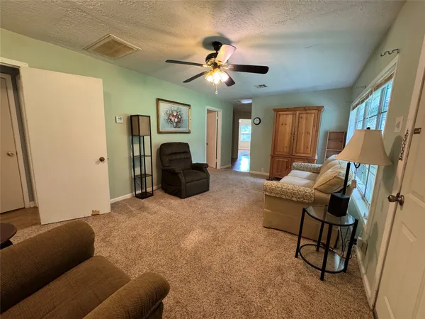 a living room with furniture and a ceiling fan