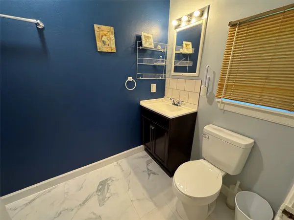 a bathroom with a toilet a sink and mirror