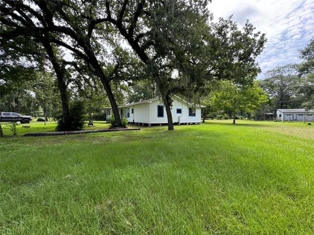 a view of grassy field with benches and trees all around