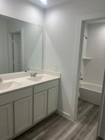 a bathroom with a double vanity sink and a mirror
