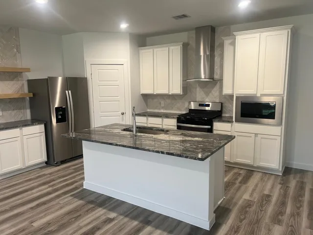 a kitchen with a sink stove and refrigerator