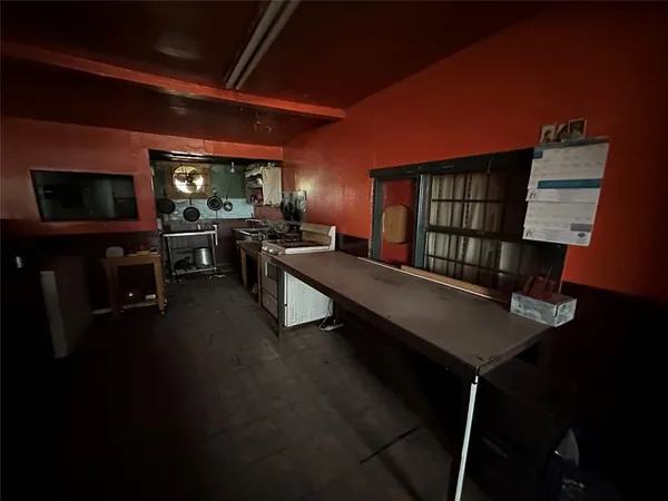 a living room with furniture a flat screen tv and kitchen view