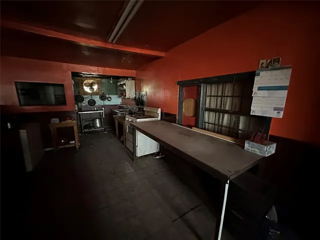 a living room with furniture a flat screen tv and kitchen view