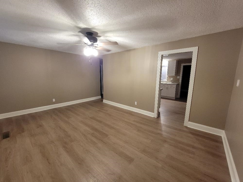 913 Chambliss Road Memphis, TN 38116 - Photo 3 of 16 Spacious room featuring wood-finish flooring, neutral-toned walls, and white baseboards