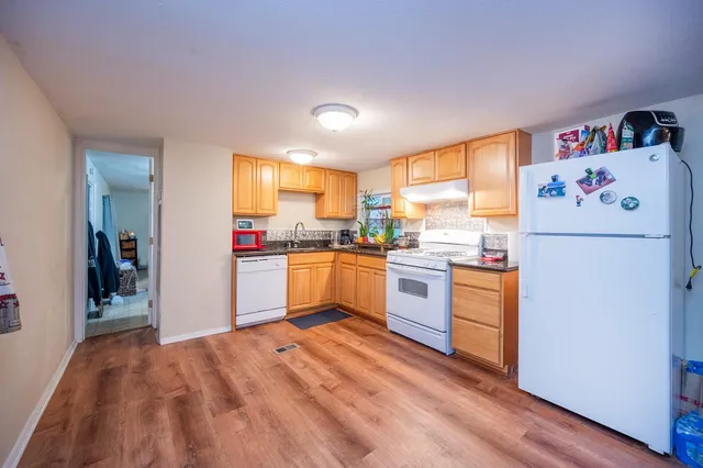 a kitchen with granite countertop appliances a sink and a refrigerator