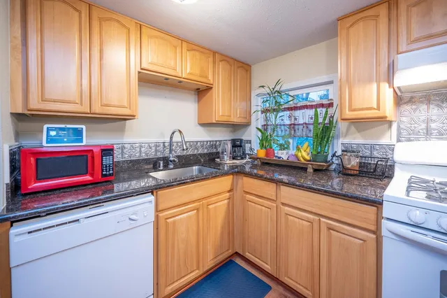 a kitchen with stainless steel appliances granite countertop a sink a stove and cabinets