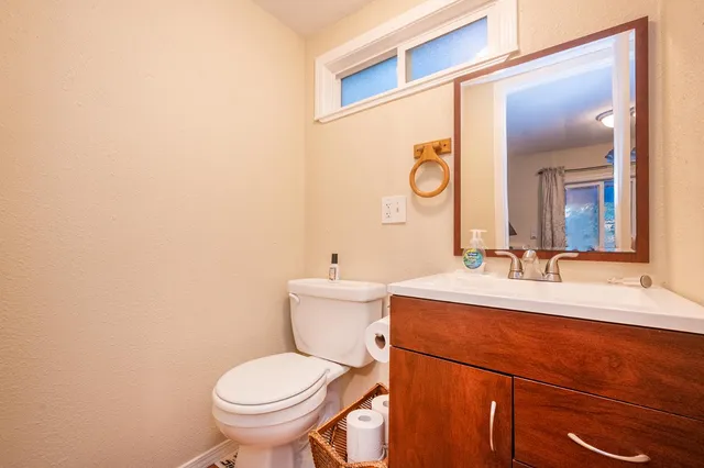 a bathroom with a toilet a sink and mirror