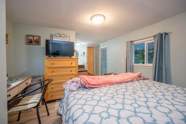 a bedroom with a bed and a flat screen tv
