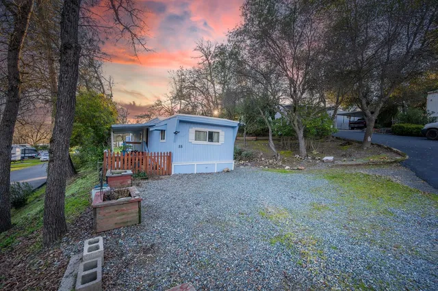 a view of a house with a yard and tree s