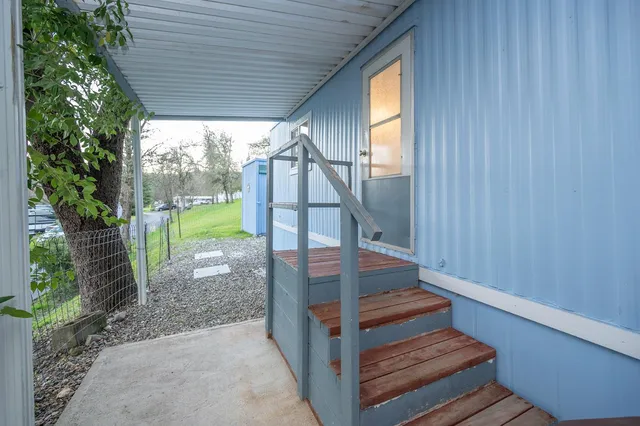 a view of a patio with table and chairs with wooden floor and garden view