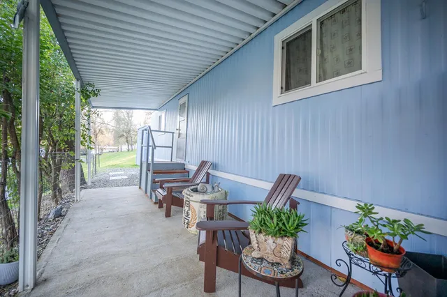 a view of a patio with furniture and a garden