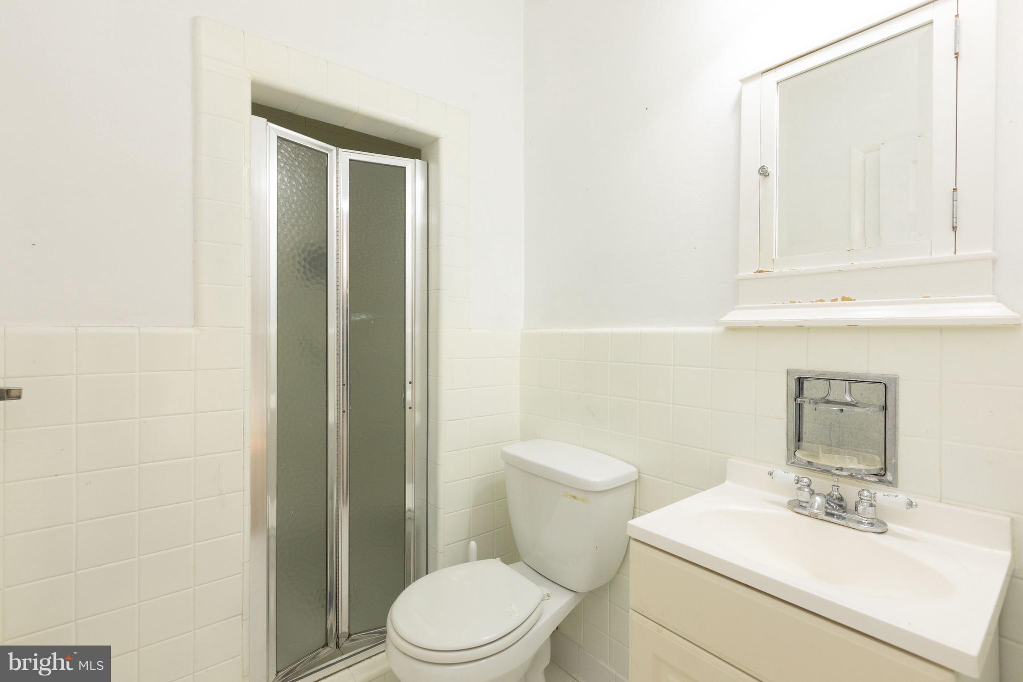 15414 Peach Orchard Road Silver Spring, MD 20905 - Photo 13 of 19 a white toilet sitting next to a bathroom sink