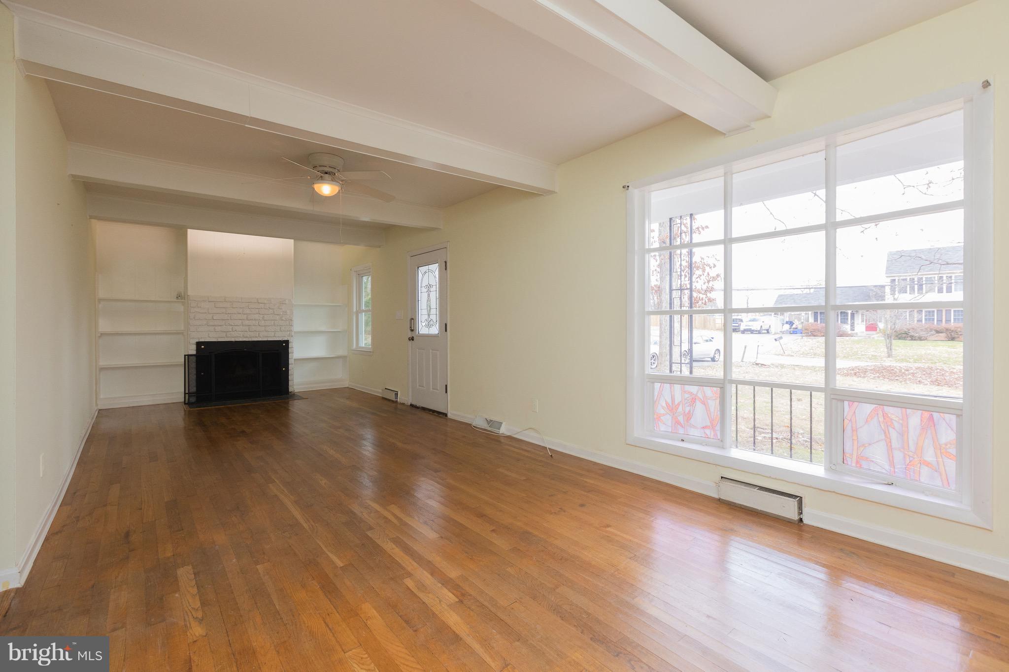 15414 Peach Orchard Road Silver Spring, MD 20905 - Photo 4 of 19 a view of an empty room with a window and wooden floor