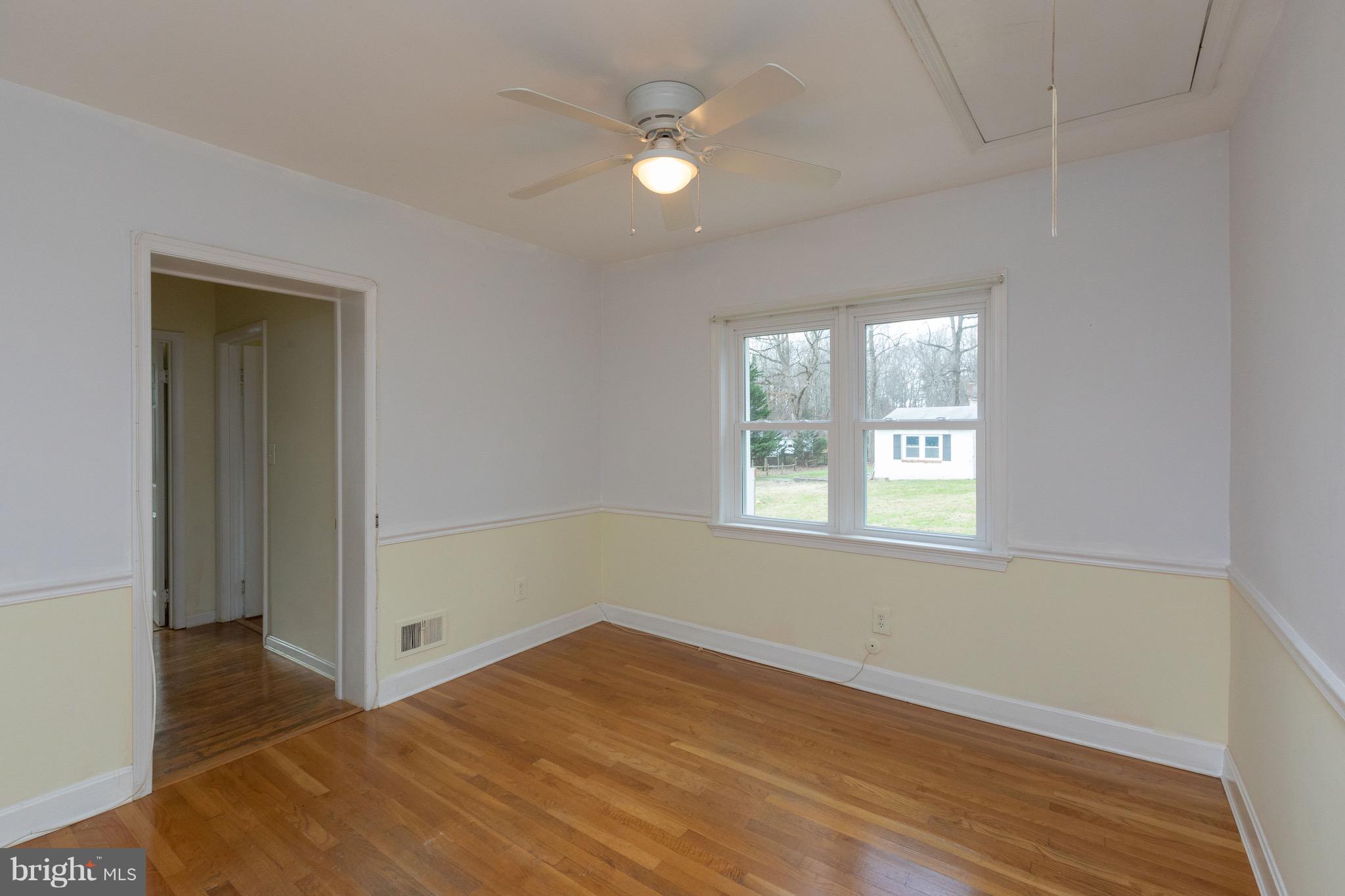 15414 Peach Orchard Road Silver Spring, MD 20905 - Photo 9 of 19 an empty room with wooden floor and windows