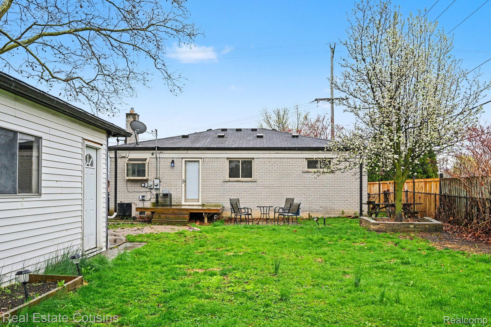 32224 Joy Road Livonia, MI 48150 - Photo 24 of 33 Rear view of property featuring brick siding, a deck, and a chimney