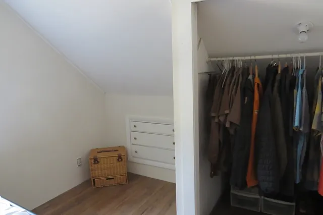 a view of walk in closet with clothes and shoes