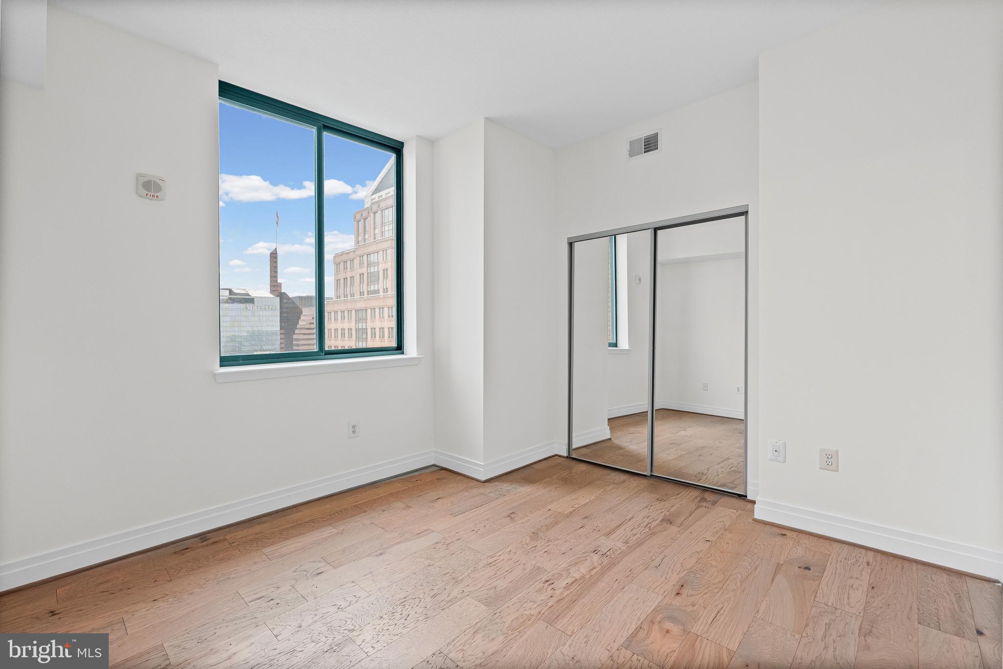 414 Water Street, Unit 2903 Baltimore, MD 21202 - Photo 18 of 46 an empty room with a mirror and a window