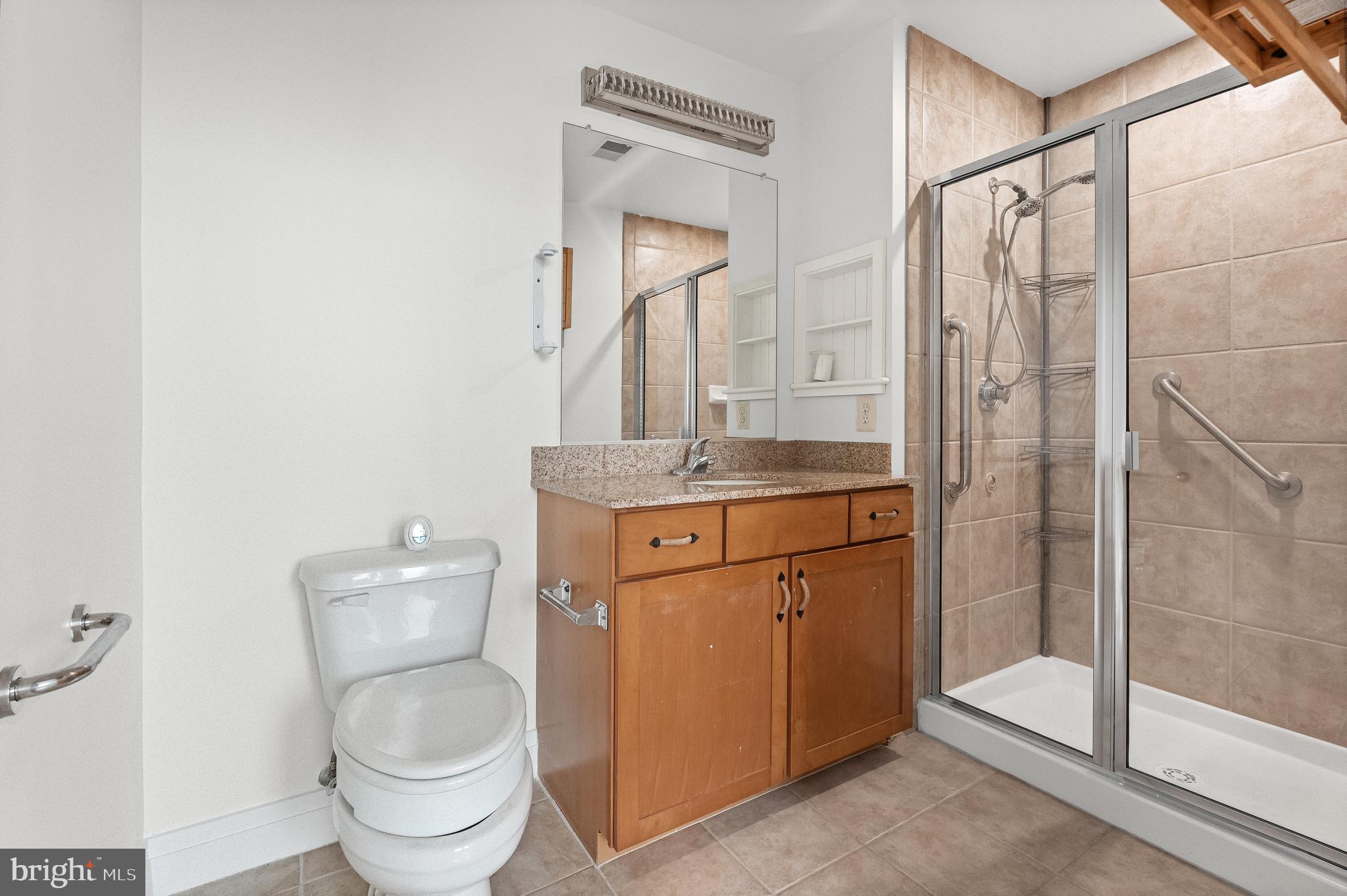 414 Water Street, Unit 2903 Baltimore, MD 21202 - Photo 19 of 46 a bathroom with a granite countertop sink toilet and shower