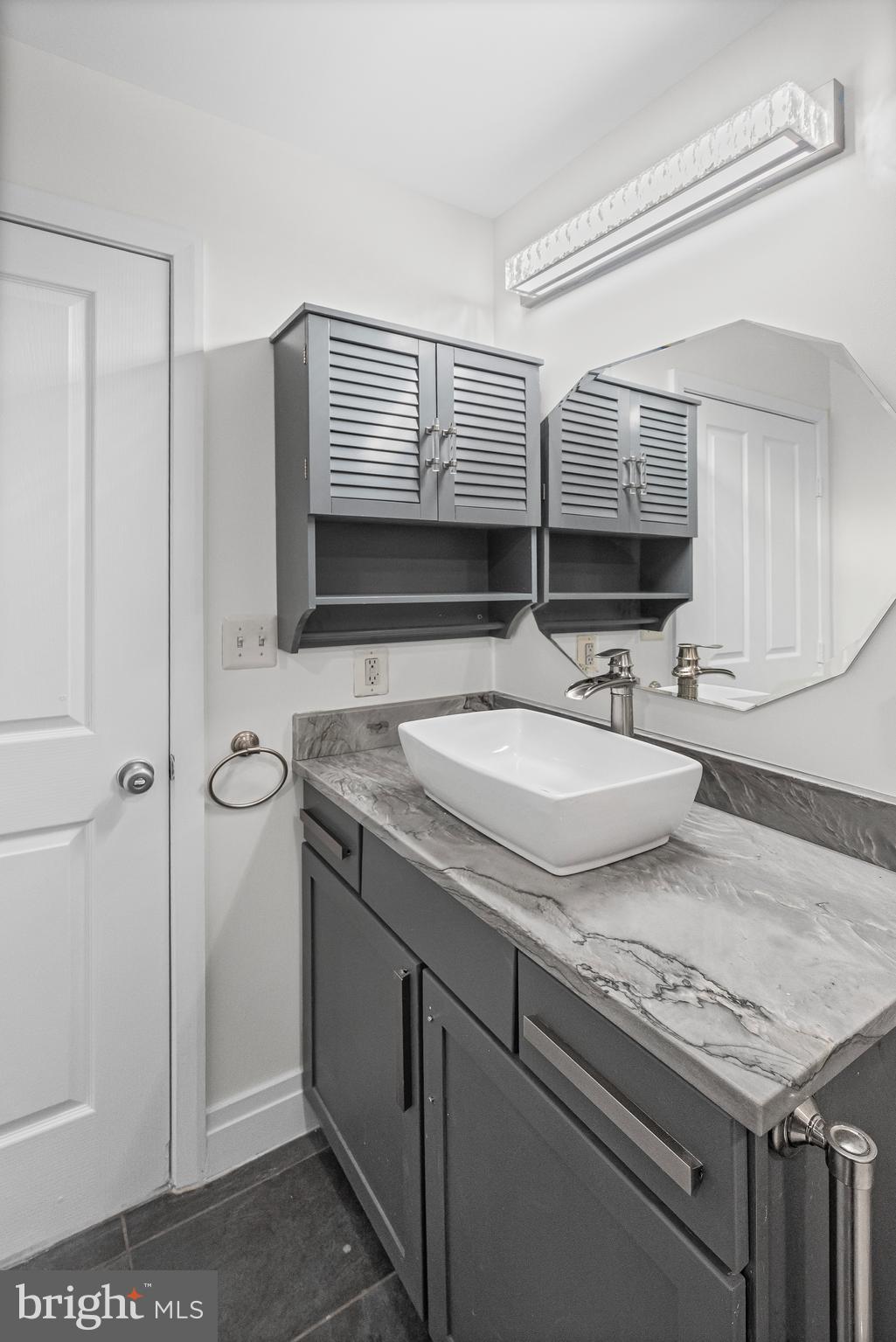 414 Water Street, Unit 2903 Baltimore, MD 21202 - Photo 26 of 46 a bathroom with a granite countertop sink and a mirror