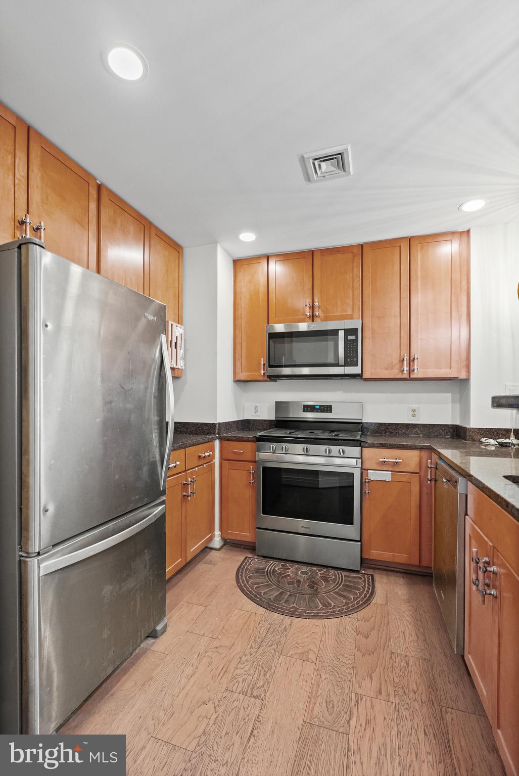 414 Water Street, Unit 2903 Baltimore, MD 21202 - Photo 6 of 46 a kitchen with granite countertop a refrigerator stove top oven and sink
