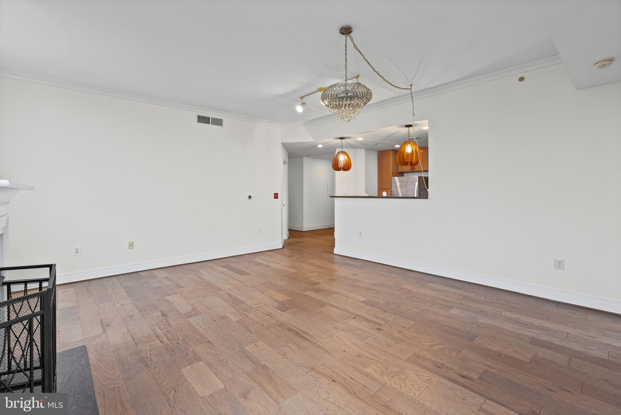 414 Water Street, Unit 2903 Baltimore, MD 21202 - Photo 7 of 46 an empty room with wooden floor stainless steel appliances and chandelier