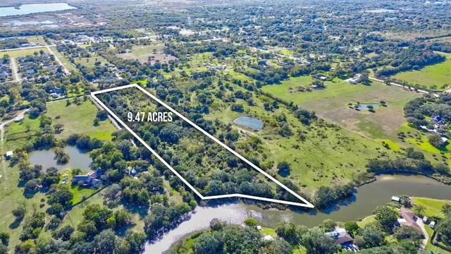 an aerial view of residential houses with outdoor space and trees