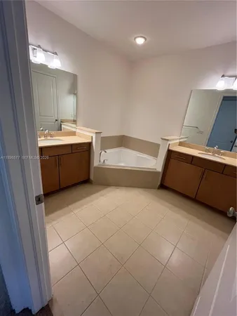 a bathroom with a bathtub sink and mirror