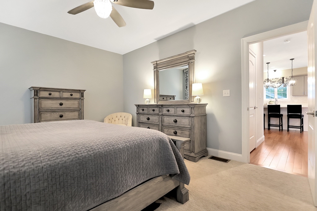 24 Del Ray Drive, Unit 25 Windham, NH 03087 - Photo 20 of 30 a bedroom with a bed and a chandelier