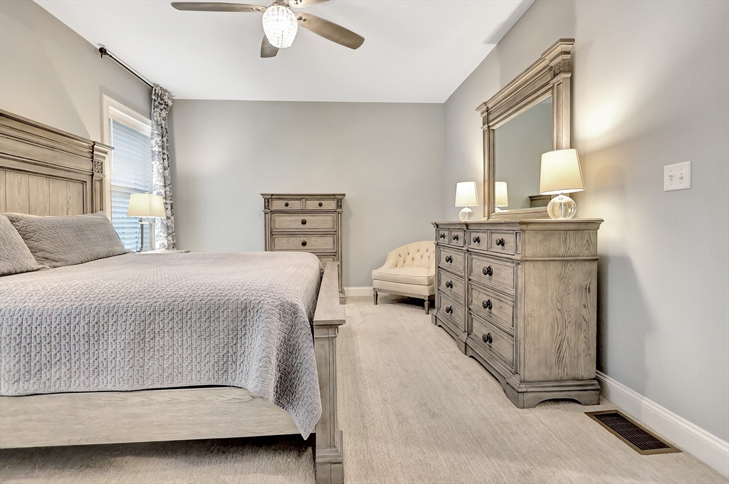 24 Del Ray Drive, Unit 25 Windham, NH 03087 - Photo 22 of 30 a bedroom with a bed and a chandelier