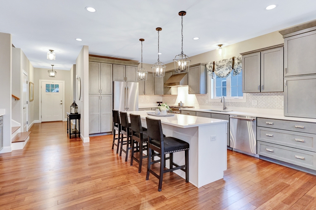 24 Del Ray Drive, Unit 25 Windham, NH 03087 - Photo 3 of 30 a kitchen with stainless steel appliances granite countertop wooden floor window and cabinets