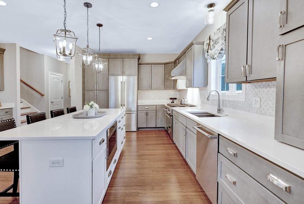 24 Del Ray Drive, Unit 25 Windham, NH 03087 - Photo 8 of 30 a large kitchen with stainless steel appliances kitchen island a large island in the center and wooden cabinets