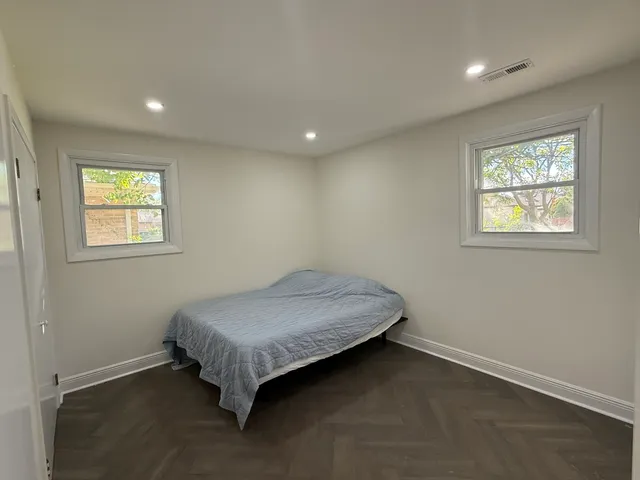 a spacious bedroom with a bed and a window