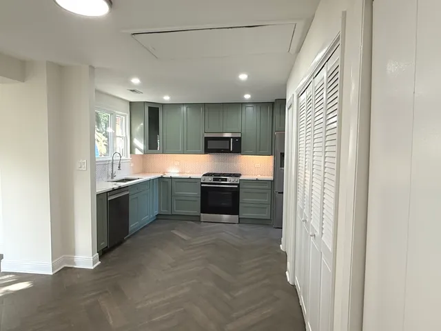 a large kitchen with a stove and a sink