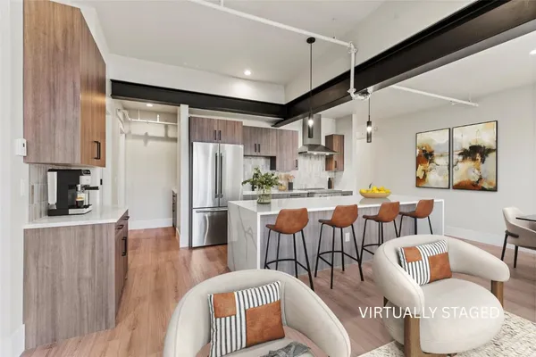 a dining room with furniture a large window and stainless steel appliances