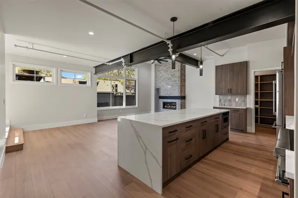a large kitchen with stainless steel appliances a large counter top and a wooden floors