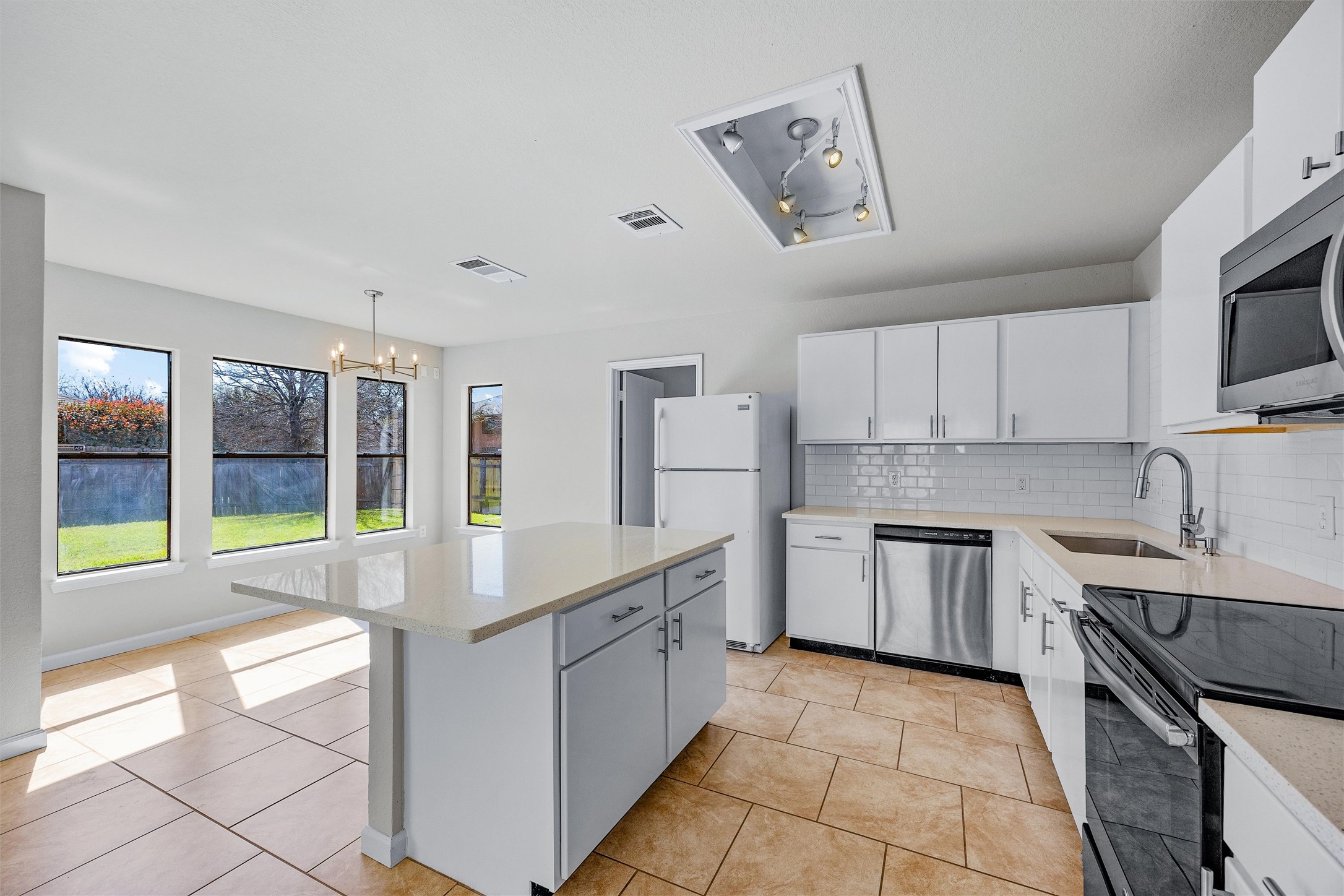 7541 Redrick Drive Austin, TX 78747 - Photo 17 of 40 Kitchen featuring visible vents, appliances with stainless steel finishes, decorative backsplash, and light countertops