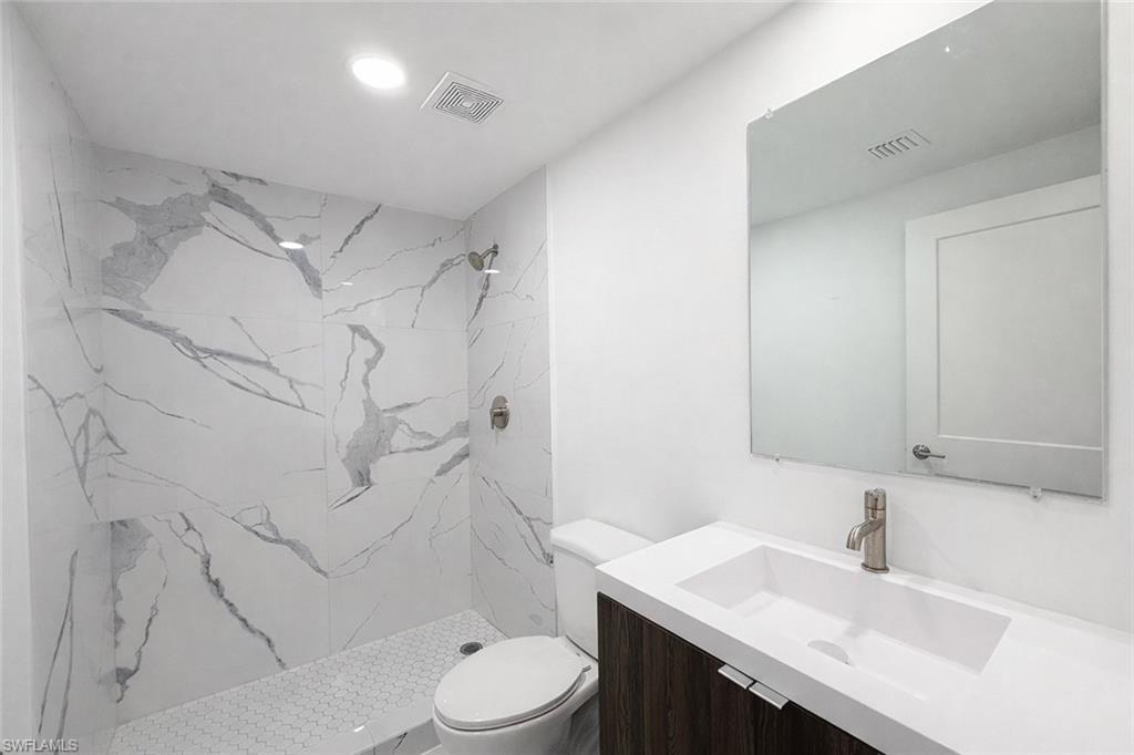 108 Indiana Place Lehigh Acres, FL 33936 - Photo 13 of 19 Full bathroom featuring a marble finish shower and vanity